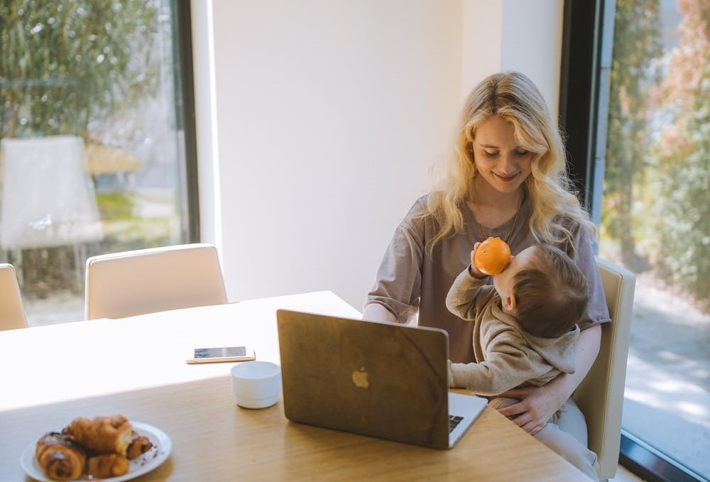 Woman working from home with a child in a remote job